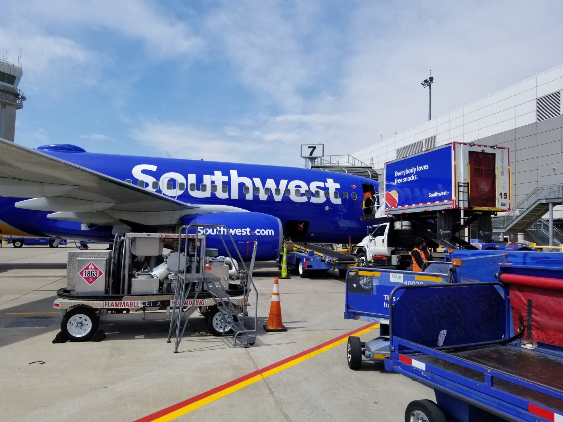 Ground vehicles assist with loading cargo onto a Southwest plane