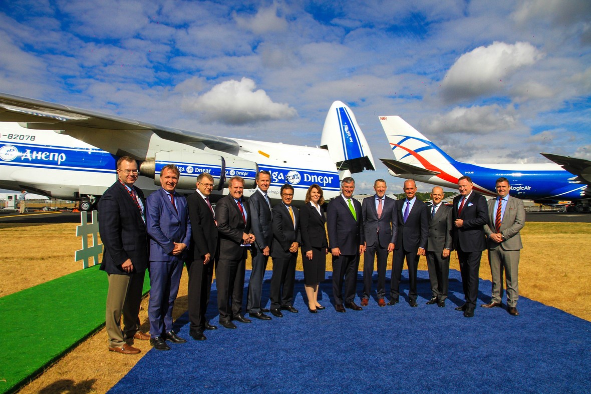 Executives from Volga-Dnepr Group, Cargo Logic Holding and Boeing stand in front of a Volga-Dnepr aircraft