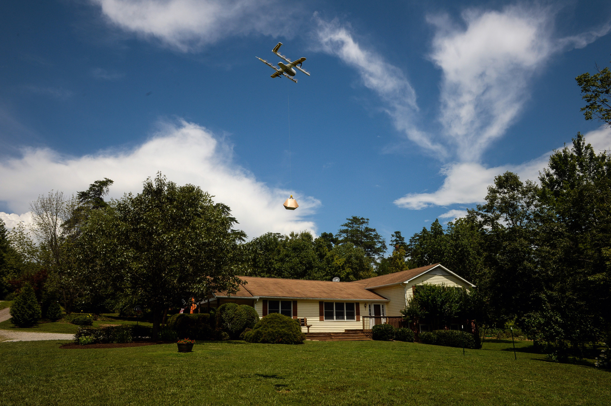Project Wing conducts example flights of their drone delivery system, in which a remotely operated drone picks up and delivers small packages, in a neighborhood next to the drone test facility at Virginia Tech in Blacksburg, VA, August 07, 2018.
BLOOMBERG/Charles Mostoller