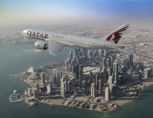 A Qatar Airways 777F flies above Doha