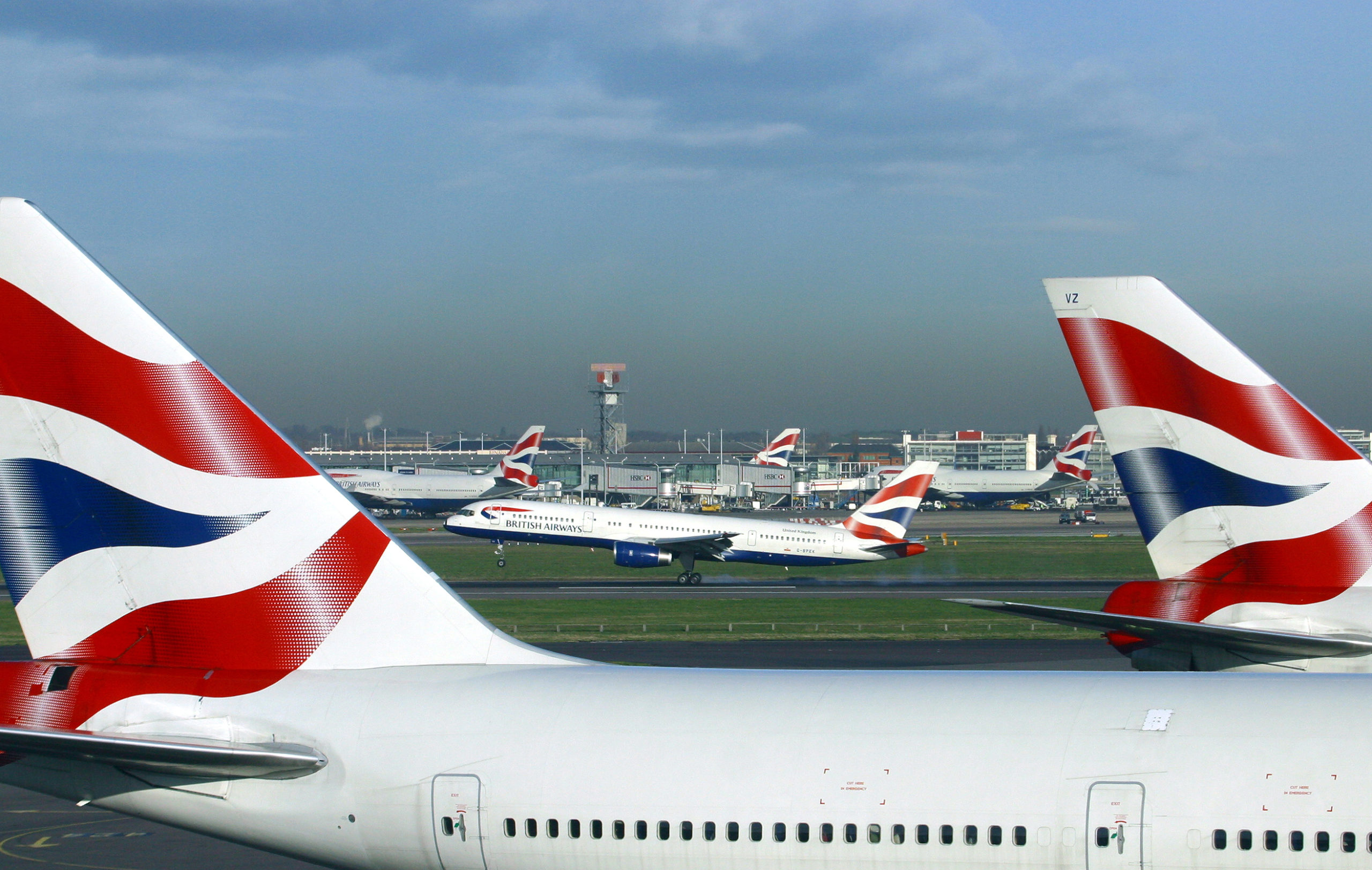 Two British Airways aircraft, with British Airways plane taking off in background.