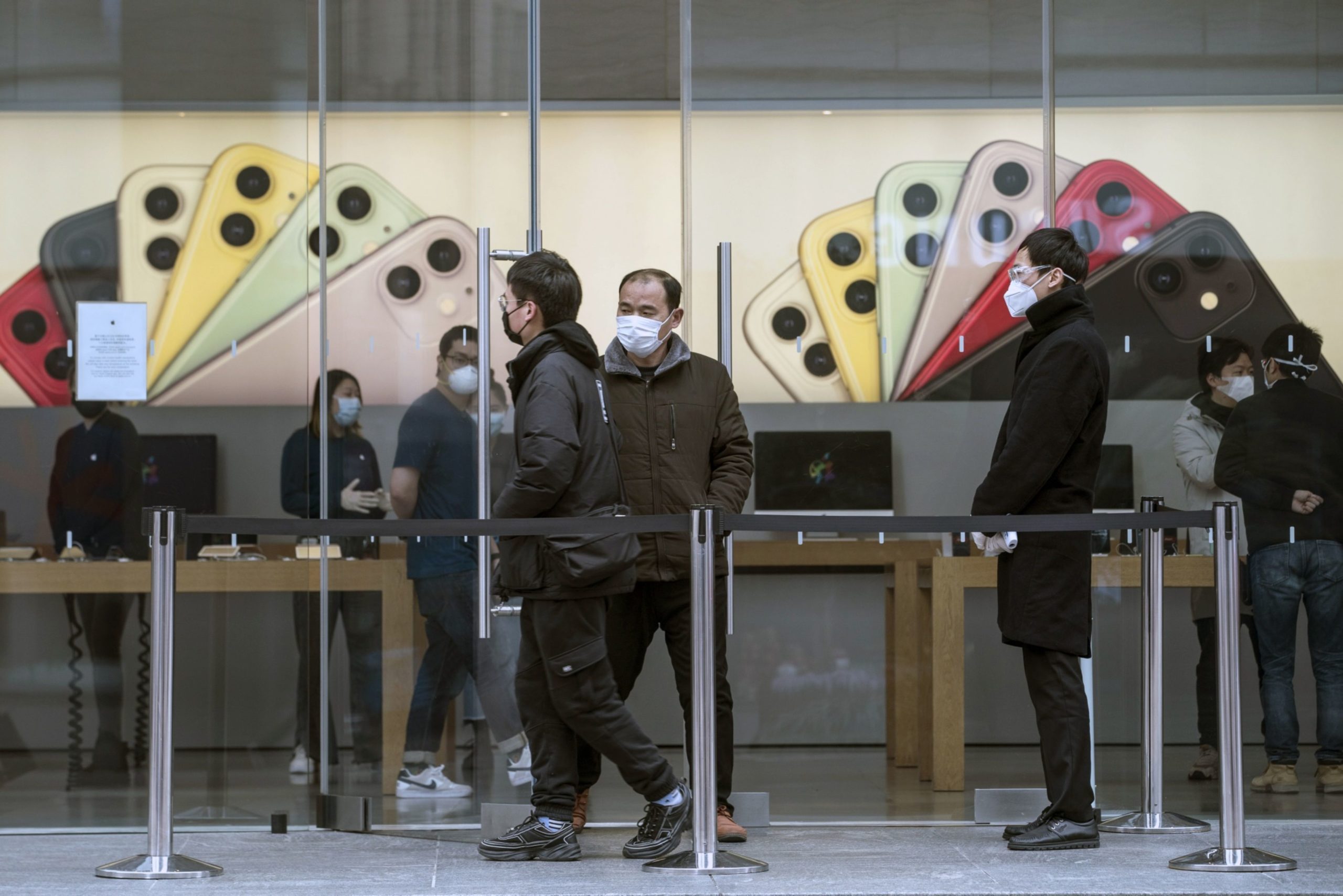 Customers wearing protective masks exit an Apple Inc. store in Shanghai, China, on Monday, March 2, 2020. The pressure to get China back to work after the coronavirus shutdown is resurrecting an old temptation: doctoring data so it shows senior officials what they want to see. Photographer: Qilai Shen/Bloomberg
