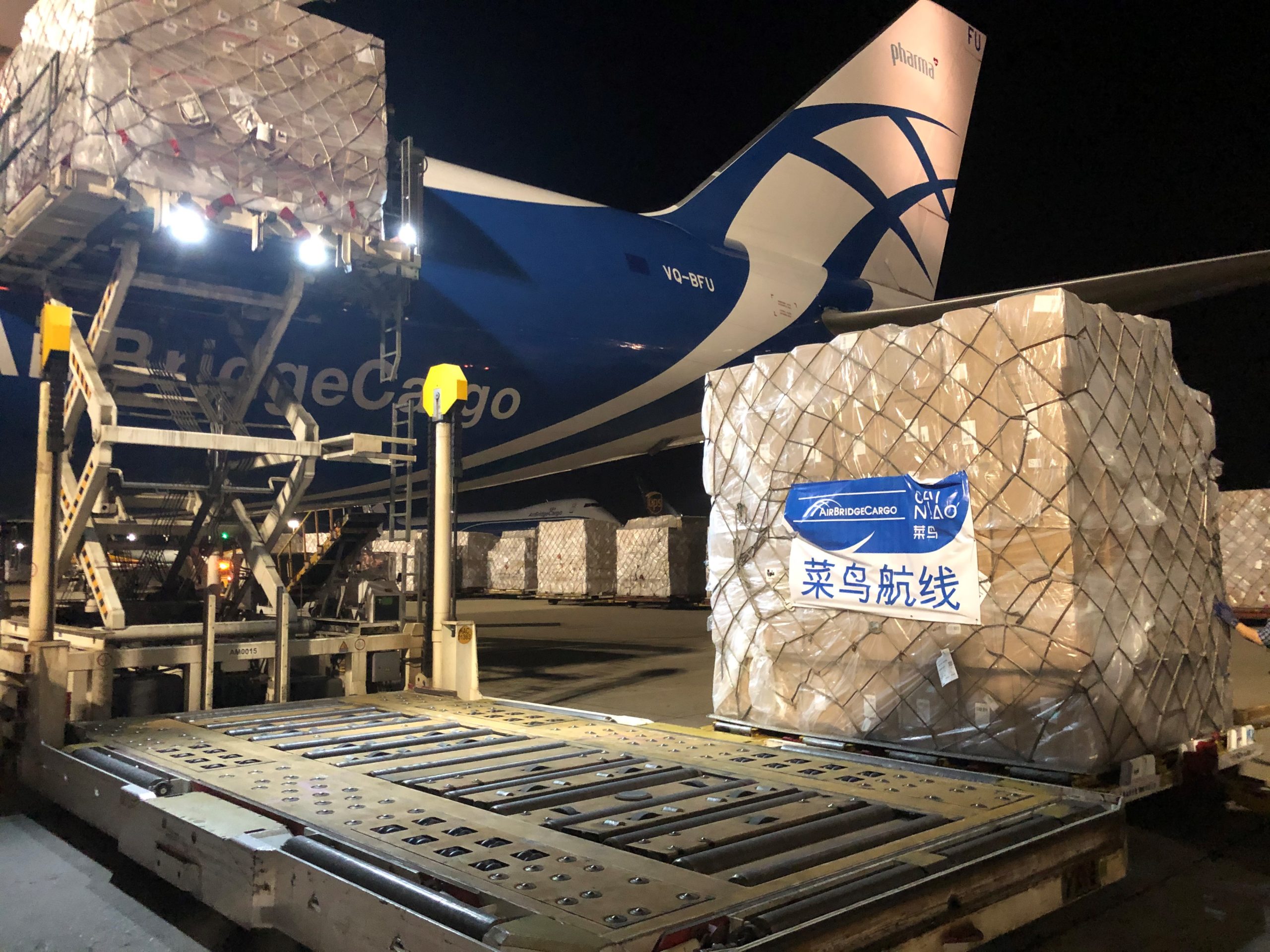 A Cainiao pallet with an AirBridgeCargo 747 tail in the background.
