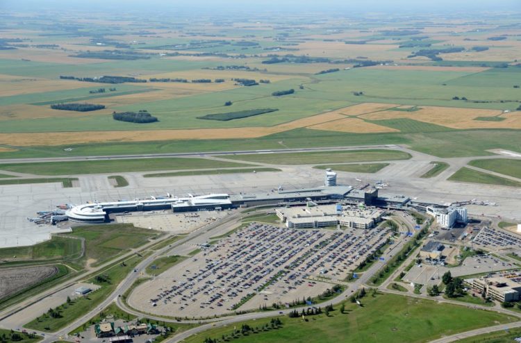Airport terminal and runway birds-eye view facing west.