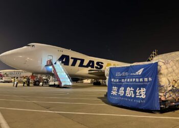 An Atlas Air airplane sits on the tarmac alongside cargo