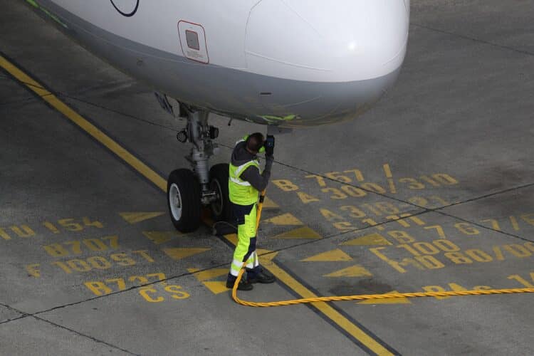 A ground crew member connects a fuel hose to an Airbus A321 aircraft