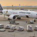 A Lufthansa Cargo plane on the tarmac surrounded by cargo