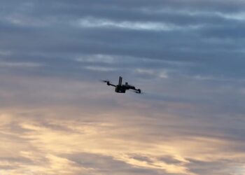 A Skydio drone flies at dusk