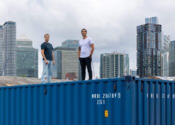 James Coombes and Nisarg Mehta stand atop a shipping container