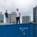 James Coombes and Nisarg Mehta stand atop a shipping container