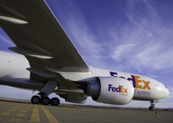 A FedEx Express plane on a runway against a blue sky