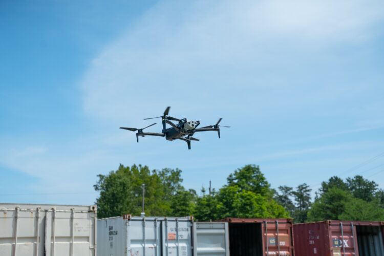 A Skydio X10 flies above a shipping yard