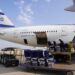 Passenger seats sit on a trolley, being taken away from a plane with the Israeli flag on its tail