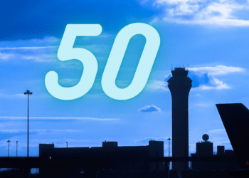 Number '50' over a blue sky with the silhouette of an airport