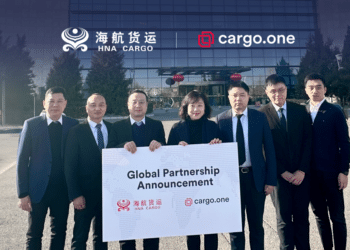 Seven people hold a sign announcing a collaboration between HNA Cargo and cargo.one