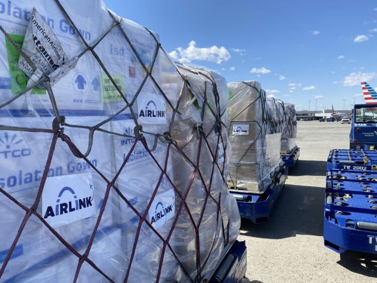 Cargo pallets with the Airlink logo wait on the tarmac