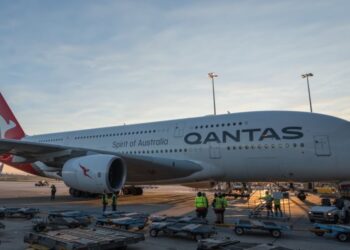 Swissport crews service a Qantas flight