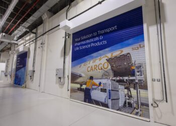 A roller door in a cargo warehouse with a picture of cargo being loaded onto an Etihad Cargo plane