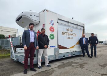 Four men stand in front of an Etihad Cargo cool dolly