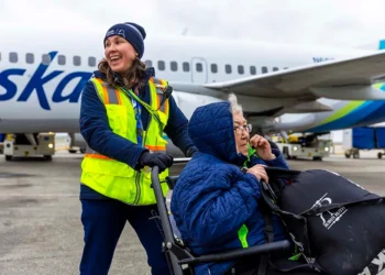 An Alaska Airlines employee asissts cancer patient, Nichole, on board a flight at Bethel Airport. (Courtesy/Alaska Airlines)