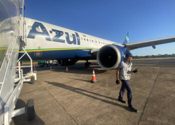 An Azul plan on the tarmac with a an employee on a walkie-talkie in the foreground