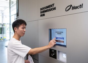 A man uses a touchscreen at a Hactl document submission hub