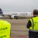 Two LATAM Airlines employees watch a LATAM Cargo plane on the tarmac